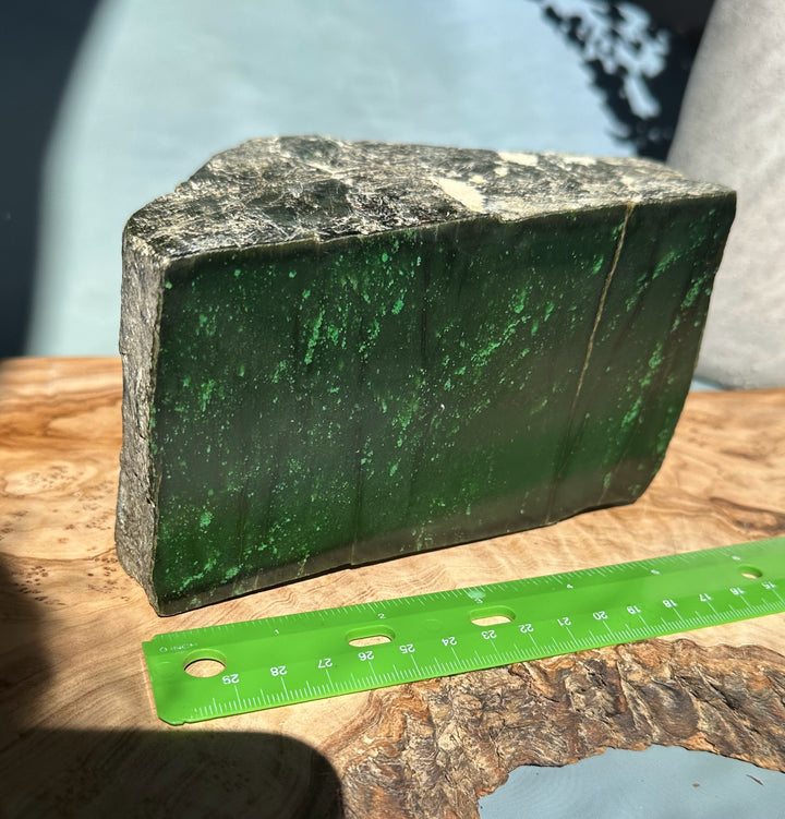 Cassiar Jade rough with brown weathered exterior and vivid green interior visible along edges.