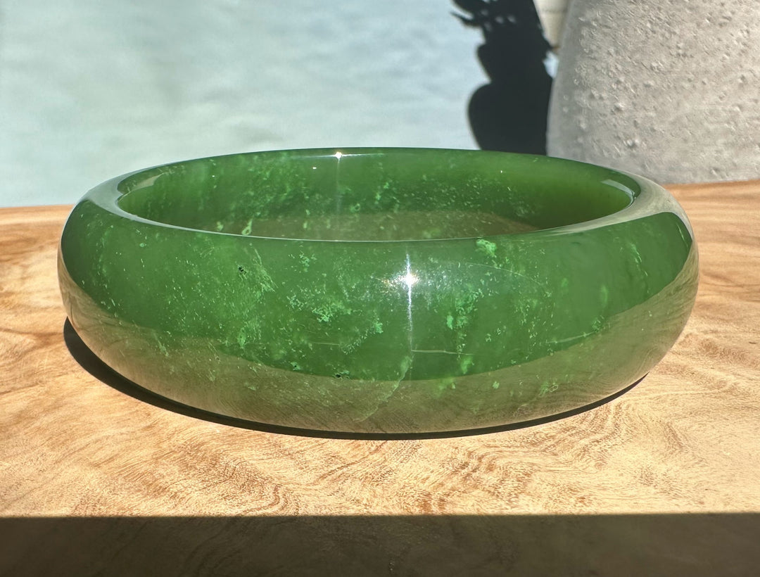 A+ Canadian jade bangle 62x19mm with inner label visible on a wooden surface.