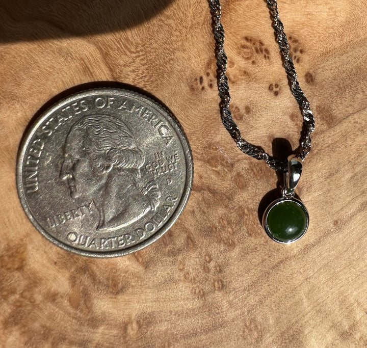 Dainty round green jade pendant set in silver with a twisted chain