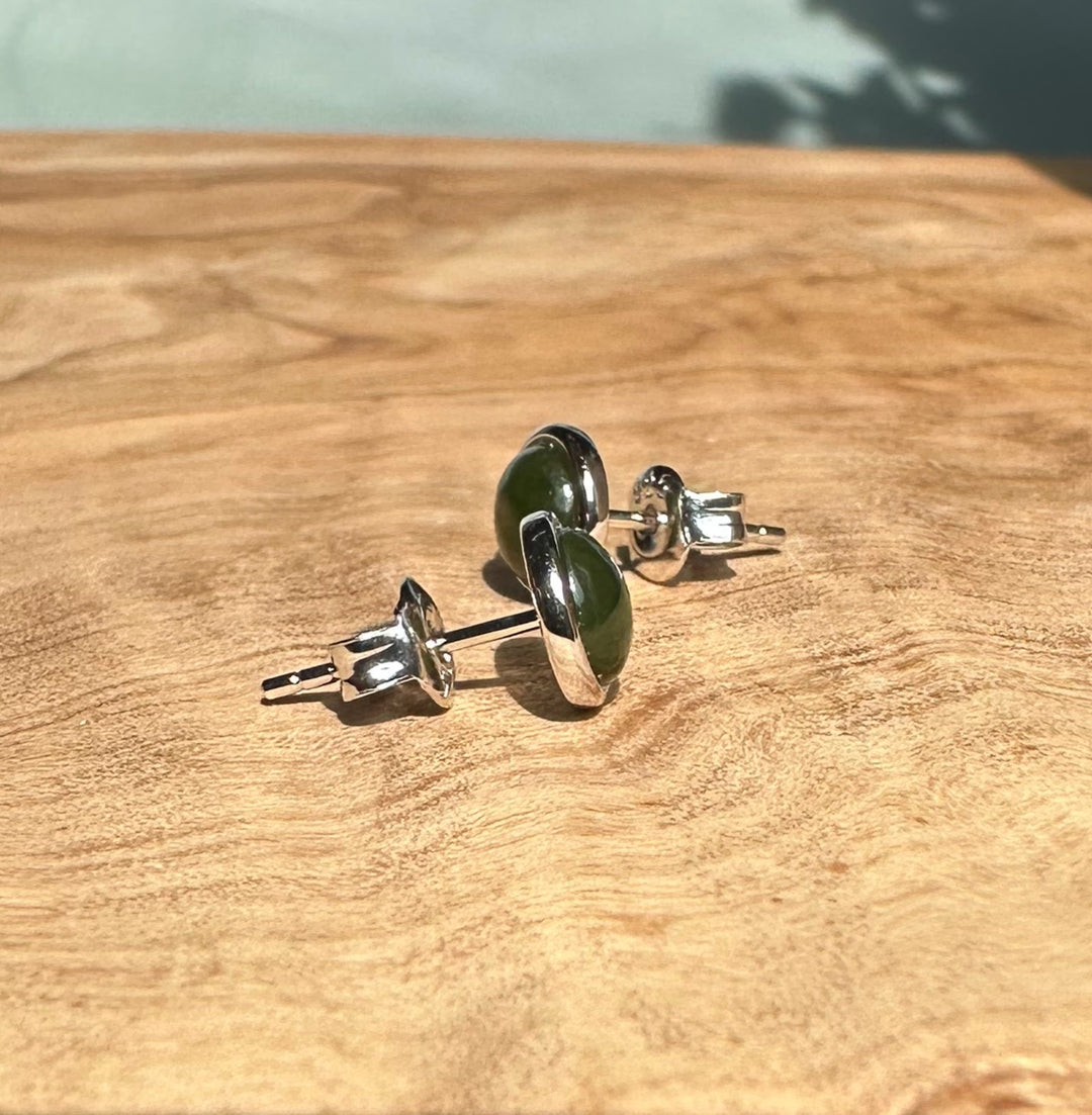 Angled side view of Silver Jade Studs featuring green jade cabochons in silver bezels