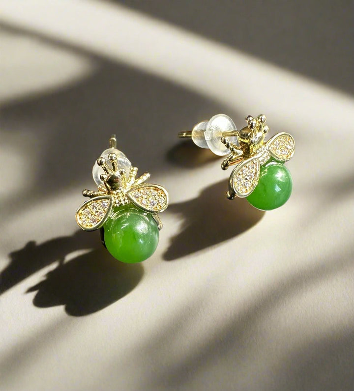 Close-up of jade bee earrings with a green jade body and diamond wings