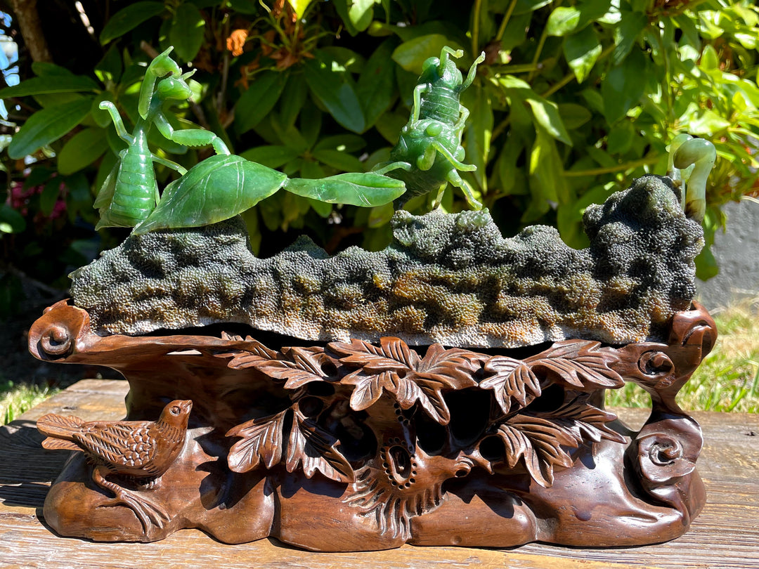 Jade carvings of praying mantis green leaves in the background