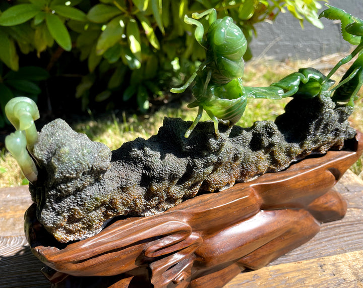 Decorative piece with green and gray stone on a wooden base outdoors