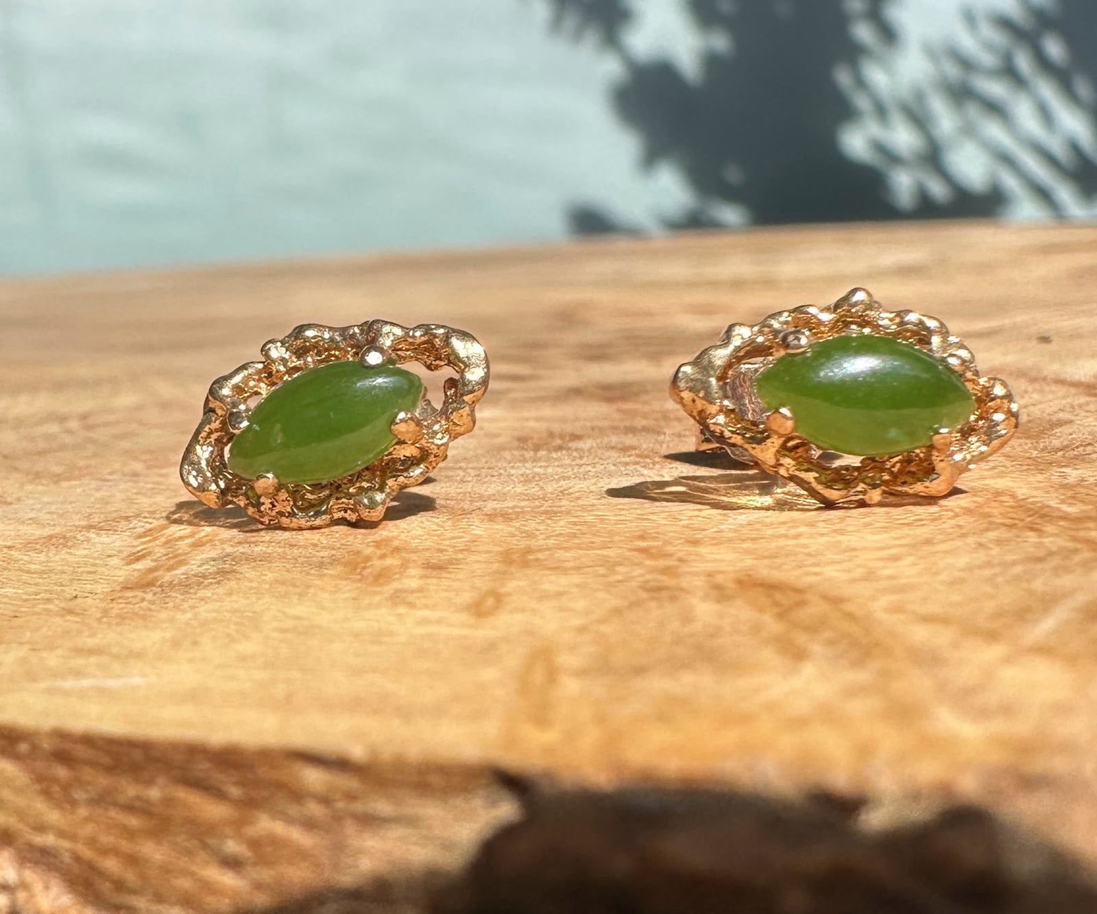 Pair of vintage jade earrings with oval green stones set in gold-tone ornate frames.