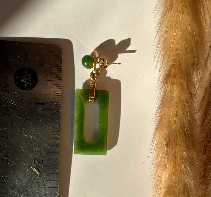 Single vintage jade rectangle drop earring with a central cutout beside a ruler for scale