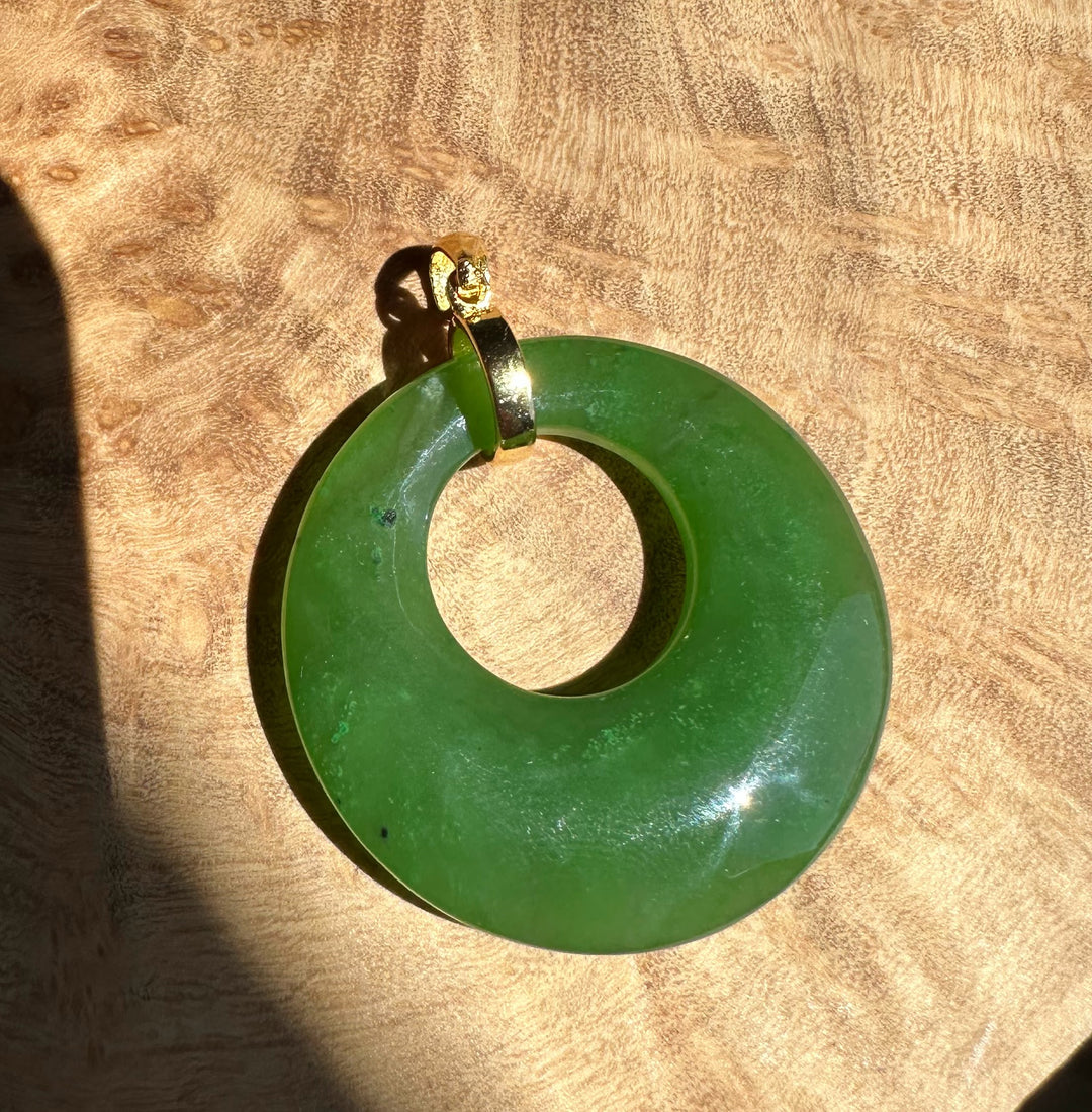 Green circular pendant on a wooden surface