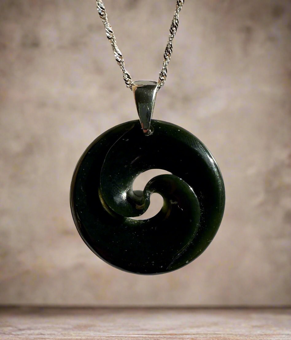 Dark green nephrite jade circular koru pendant on a silver chain