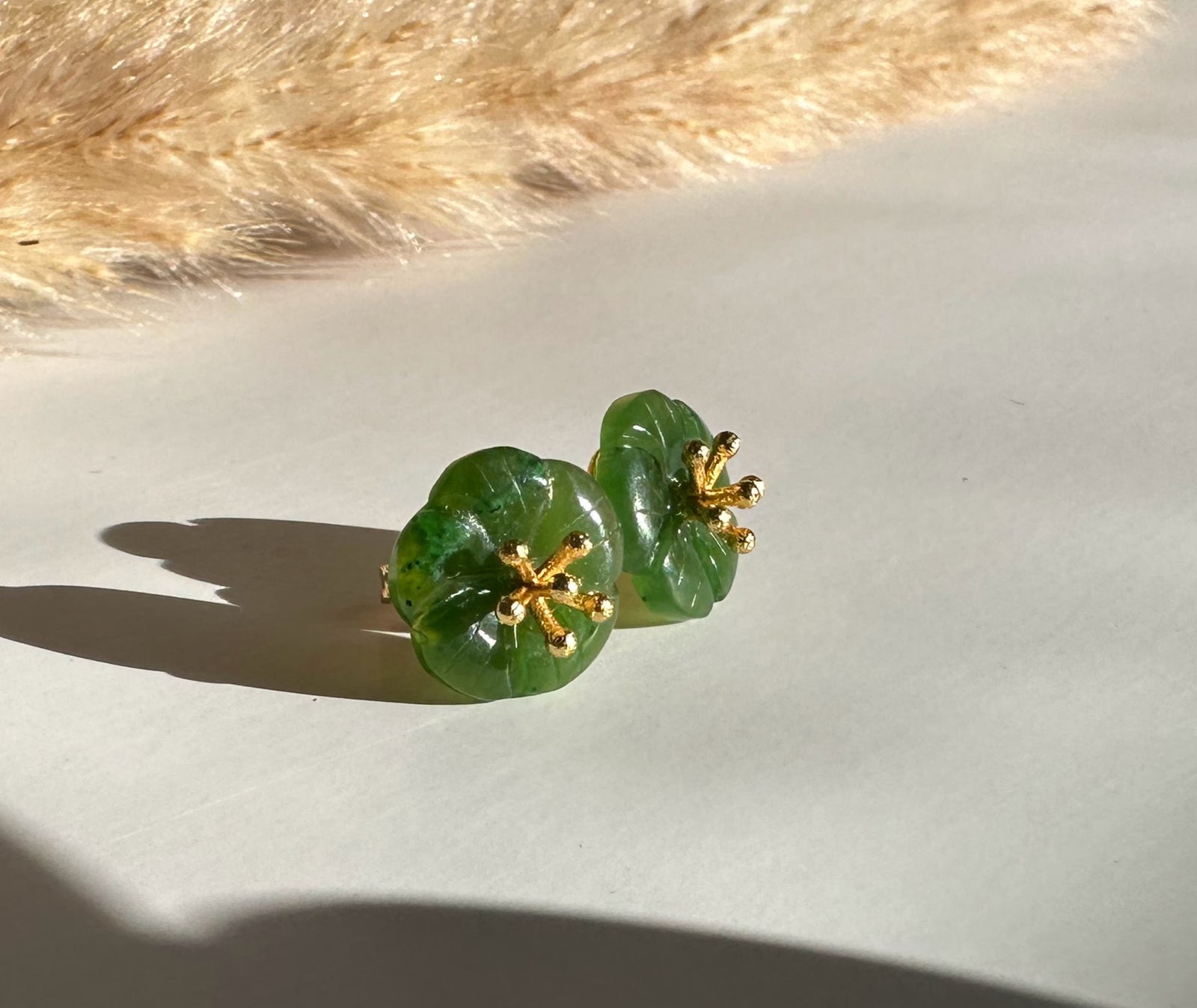 Jade Flower Earrings #504 green jade flower shapes with gold-tone stamens on a light surface.