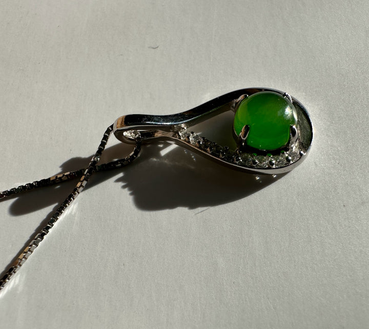 Side view of the silver Infinity pendant with green cabochon and crystals on a chain