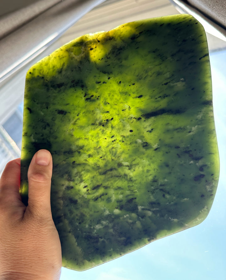 Hand holding a green jade dish