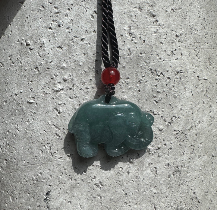Guatemalan jadeite elephant pendant on a black braided cord with a red bead