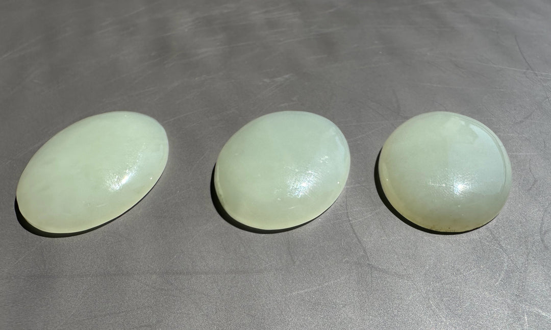 Three light white oval objects on a gray surface