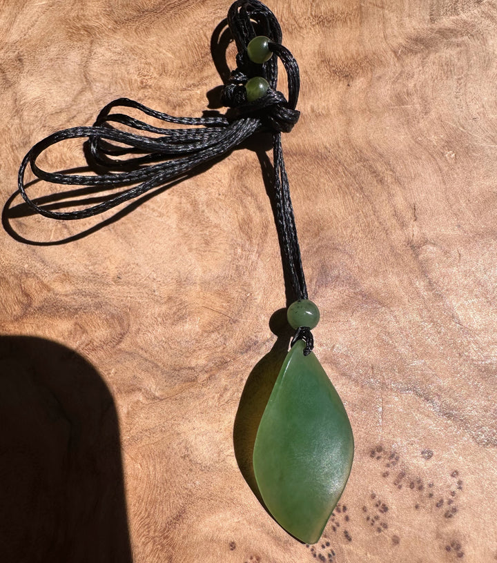 Green pendant necklace on a textured brown surface