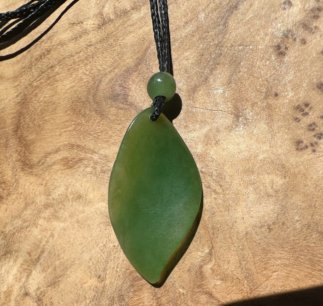 Green pendant necklace on a wooden surface