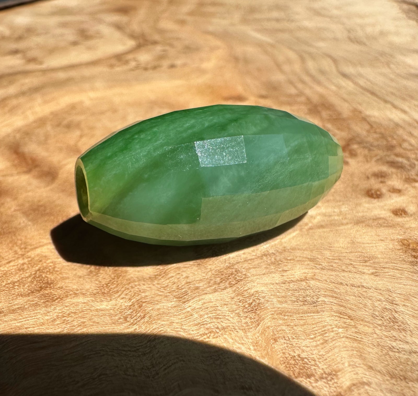 Green jade stone on a wooden surface