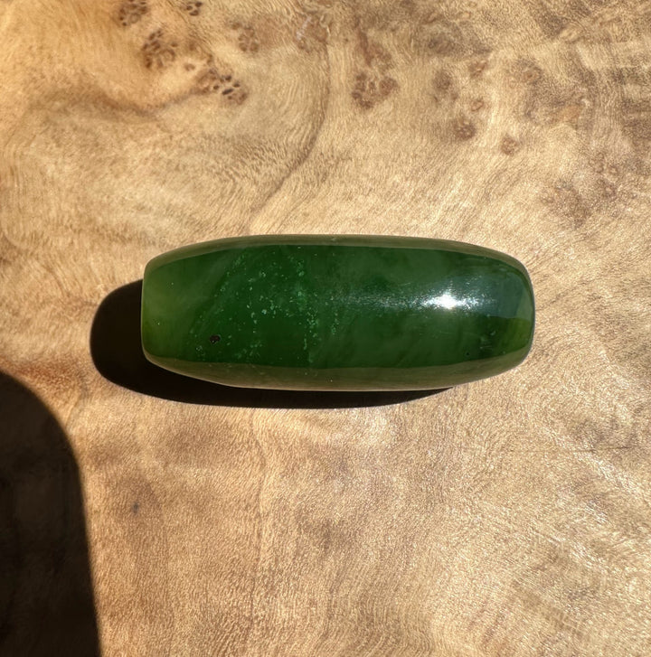 Green jade stone on a wooden surface