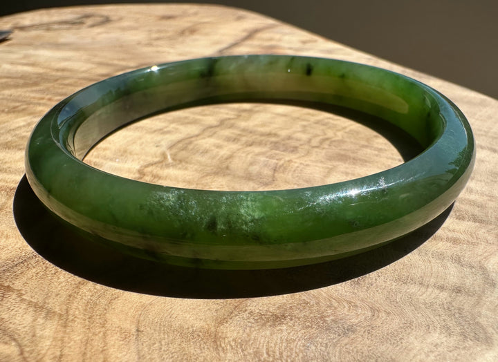 Polar green jade bangle on wooden surface