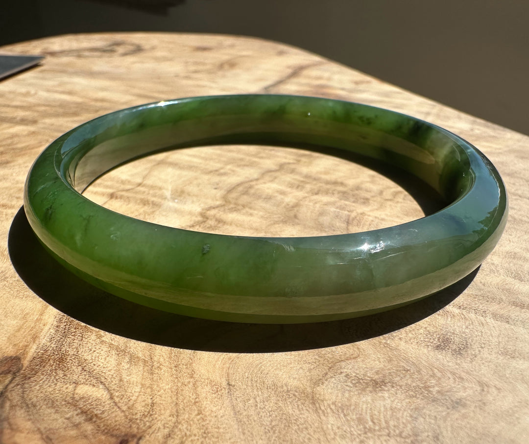 Polar green jade bangle on wooden surface