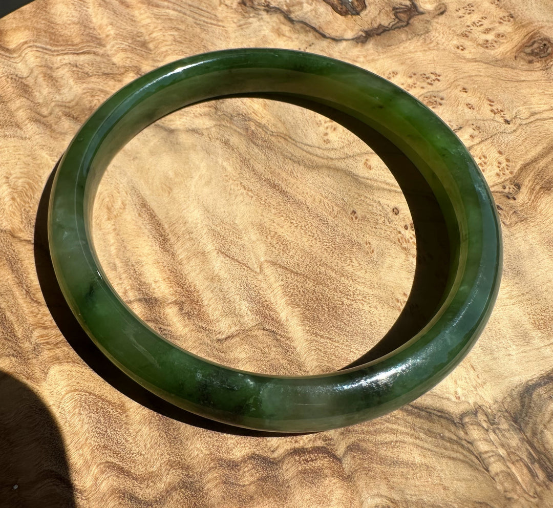 Polar green jade bangle on wooden surface