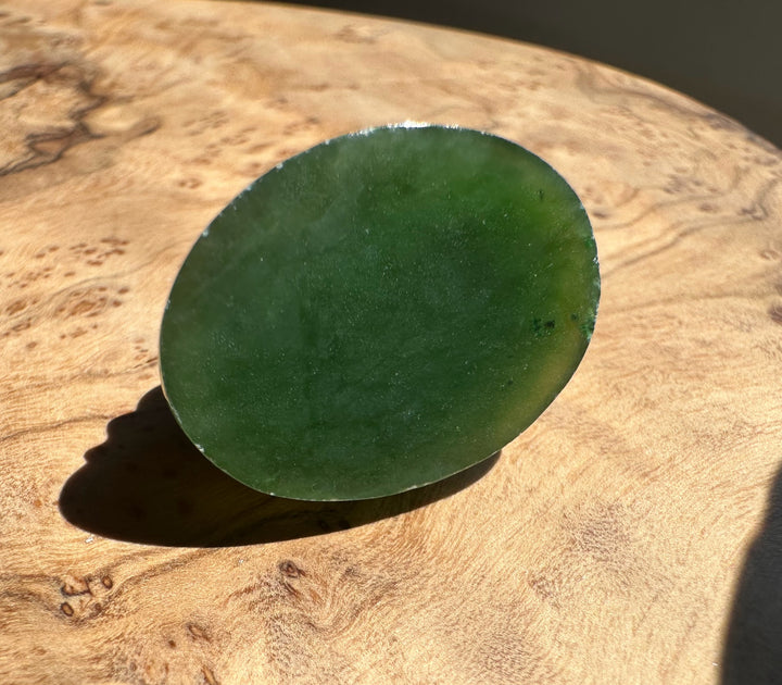Green stone bottome side on a wooden surface