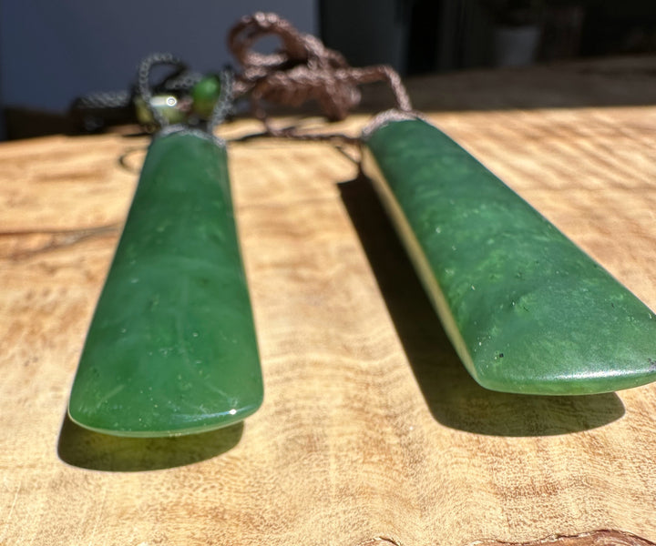 Green jade earrings on a wooden surface