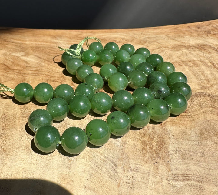 Green jade beads on a wooden surface