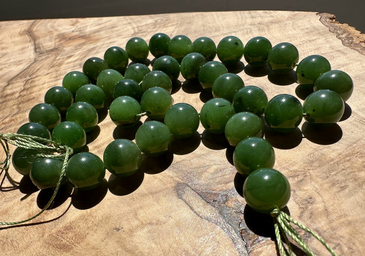 Green beads on a string on a wooden surface