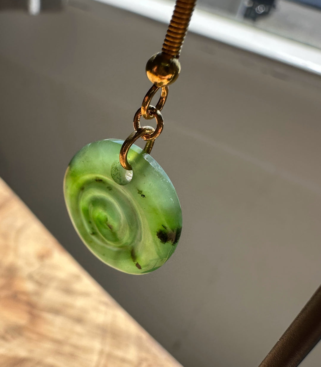 Green spiral earring on a neutral background