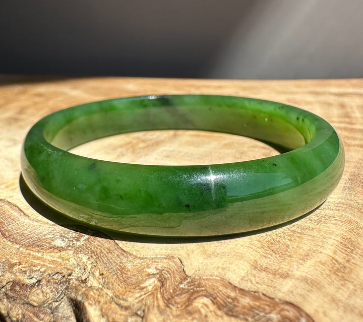 Green jade bracelet on a wooden surface