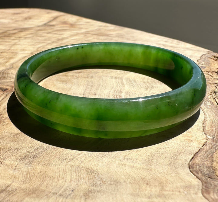 Green jade bracelet on a wooden surface