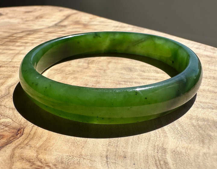 Green jade bracelet on a wooden surface