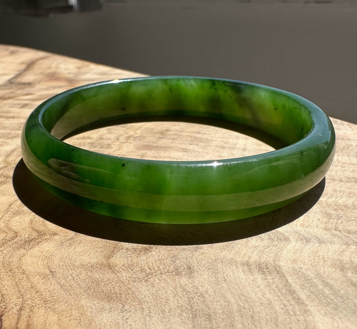 Green jade bangle on a wooden surface