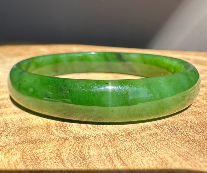 Green jade bracelet on a wooden surface