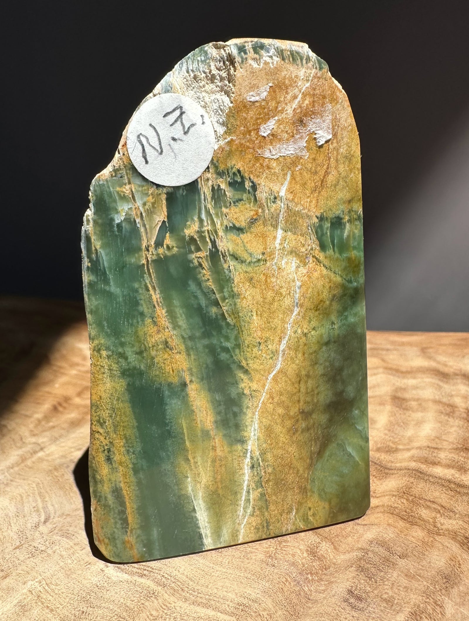 Green and brown jade with a label on a wooden surface