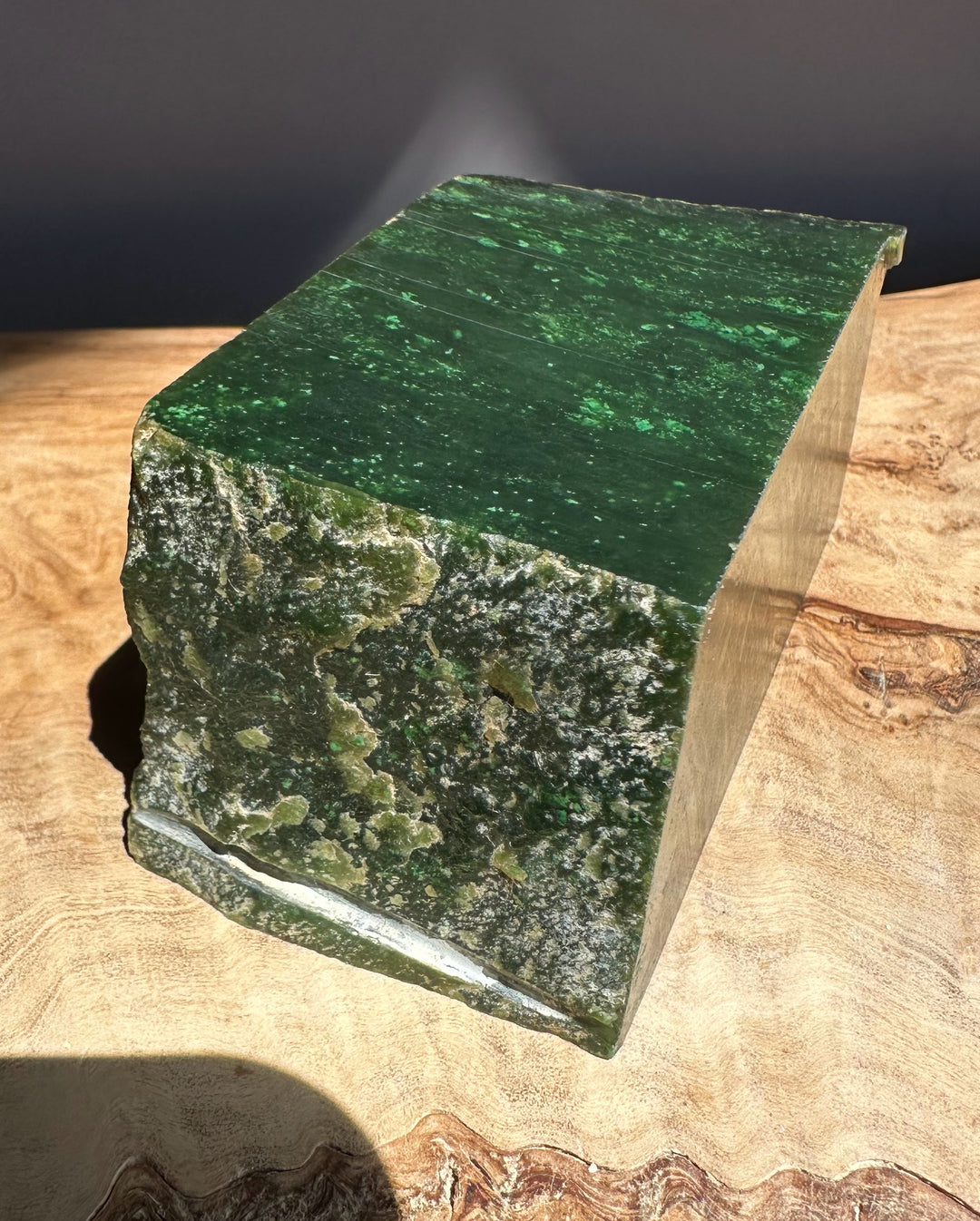 Green jade block on a wooden surface