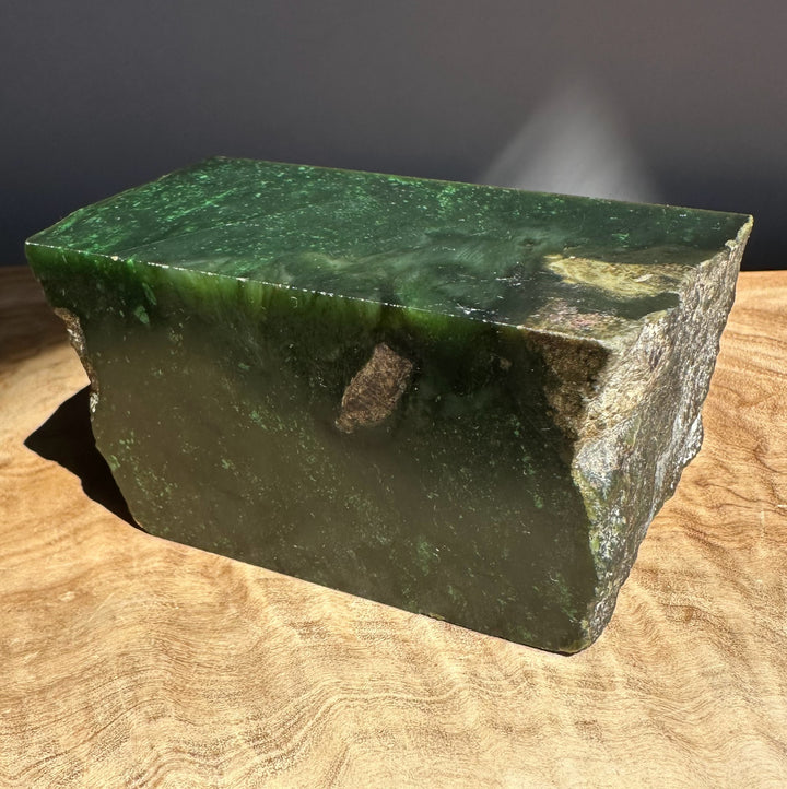 Green jade on a wooden surface with a dark background