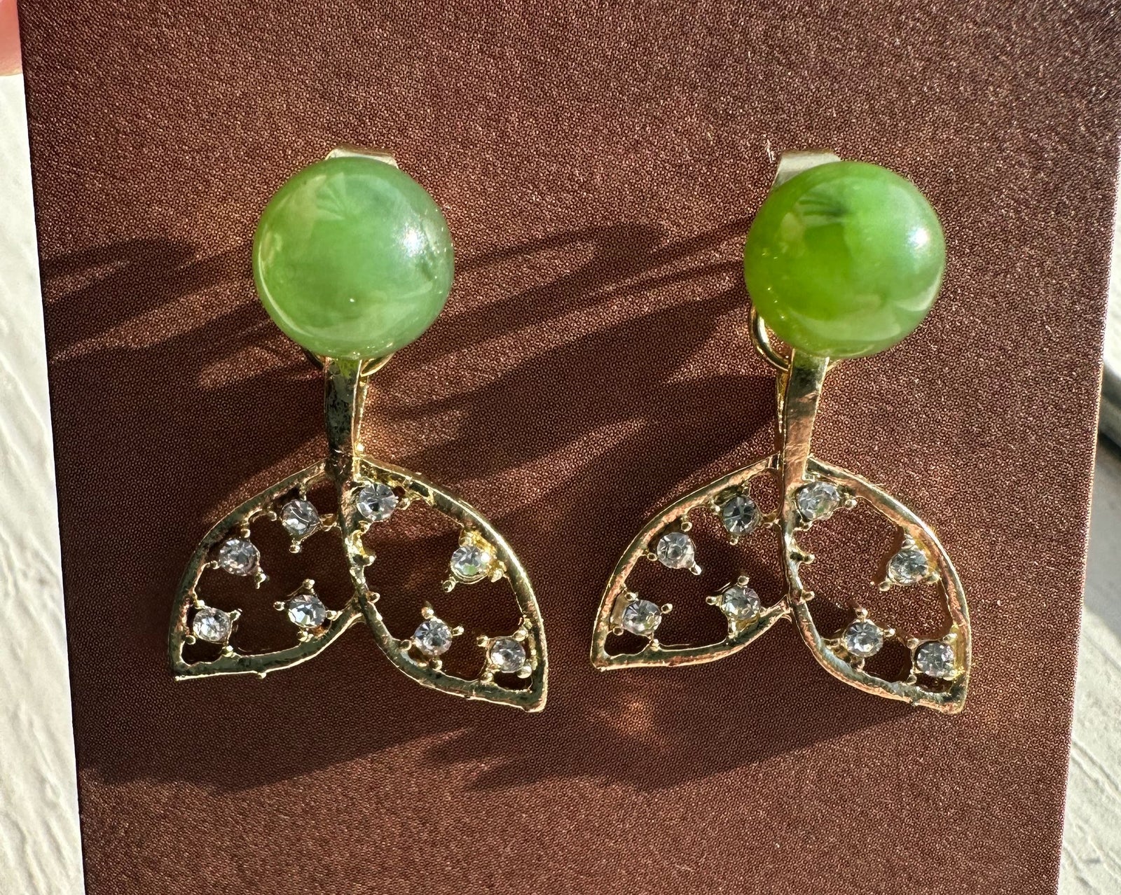 Whale tail earrings with bright green nephrite cabochons and crystal studded gold leaf tails