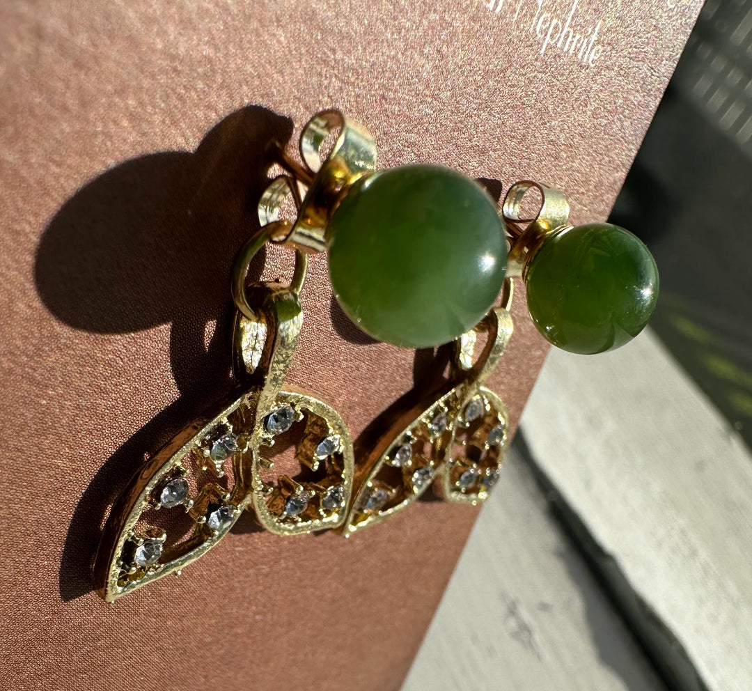 Gold tone whale tail earrings with green nephrite beads and crystal accented leaf tails