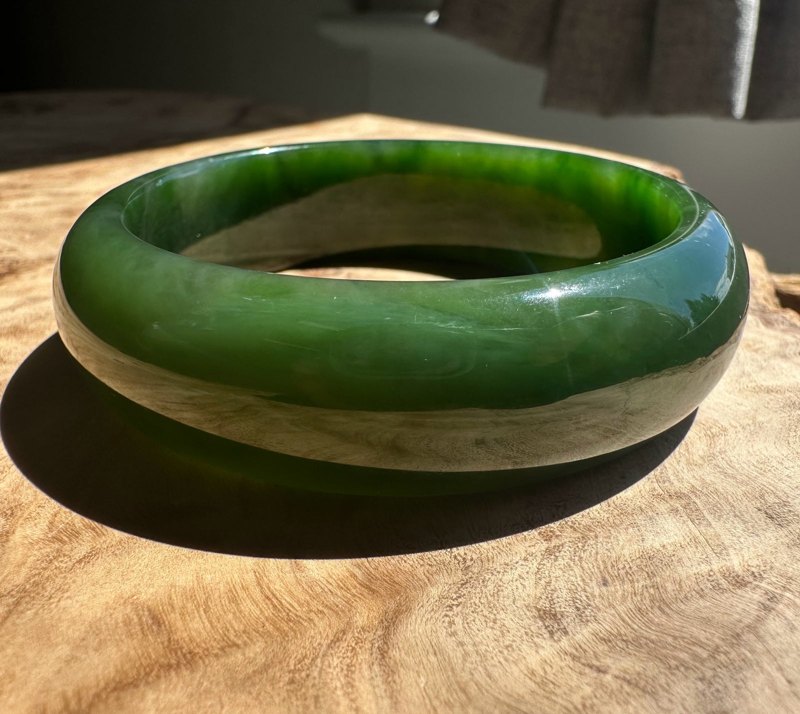 Green jade bangle on a wooden surface