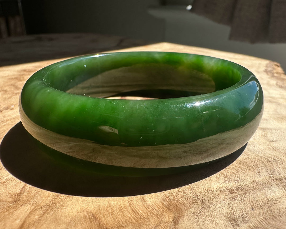 Green jade bangle on a wooden surface