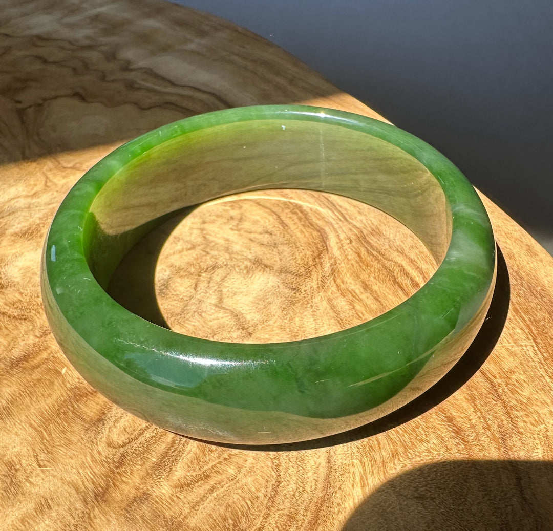 Green jade bracelet on a wooden surface