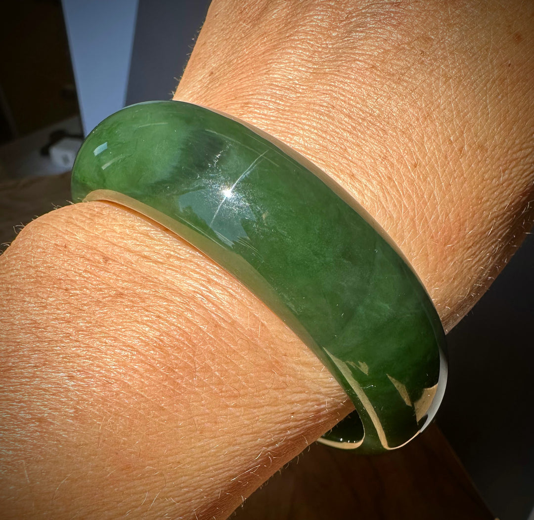 Green bracelet on a wrist with a blurred background