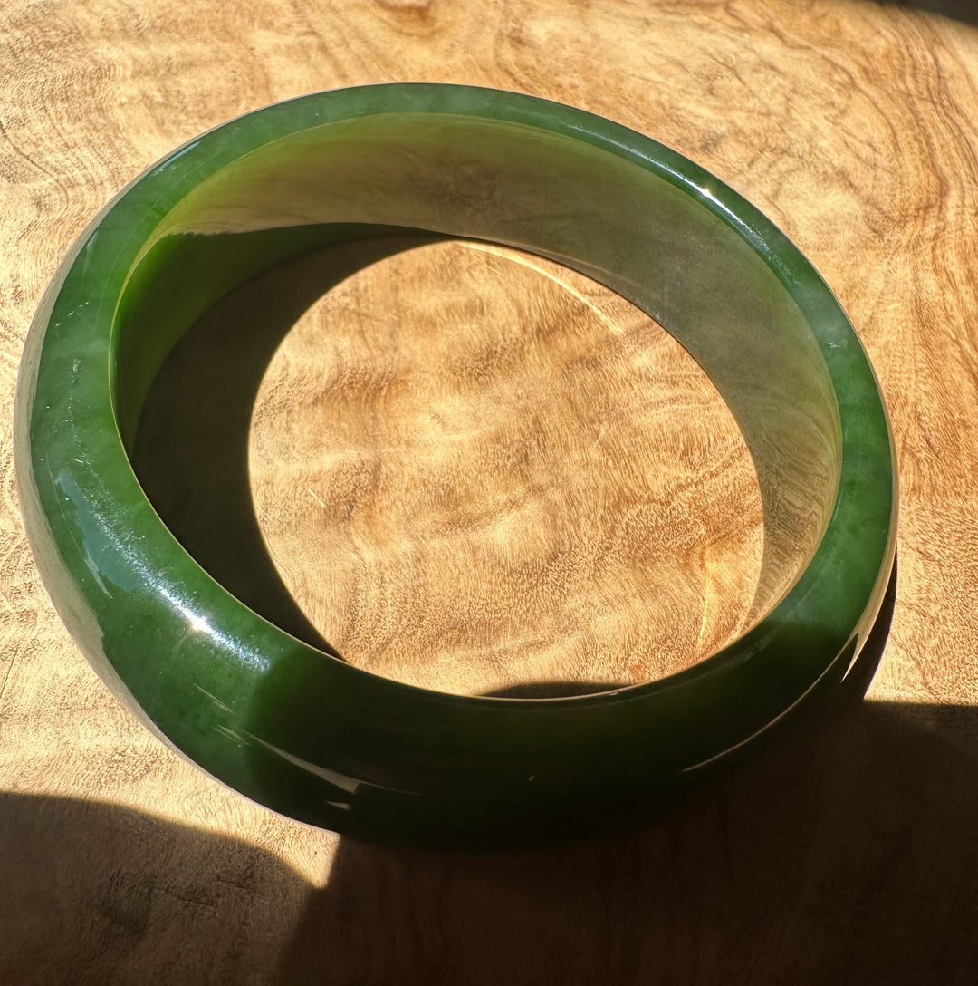 Green jade bracelet on a wooden surface