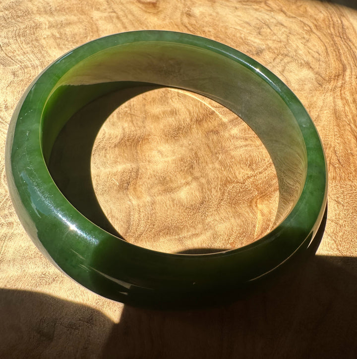 Green jade bracelet on a wooden surface