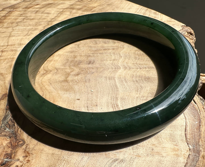 Green jade bangle on a wooden surface