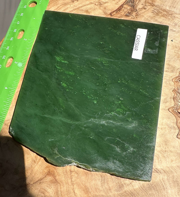 A Grade Canadian Jade Slab 240g with Cassiar label beside a bright green ruler on a wooden surface.