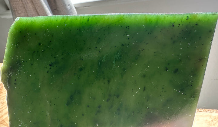 Edge view of a glossy green jade slab showing crisp edge and vibrant color