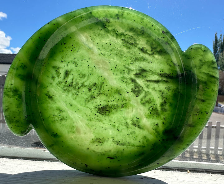 Green jade on a clear surface with a blue sky background