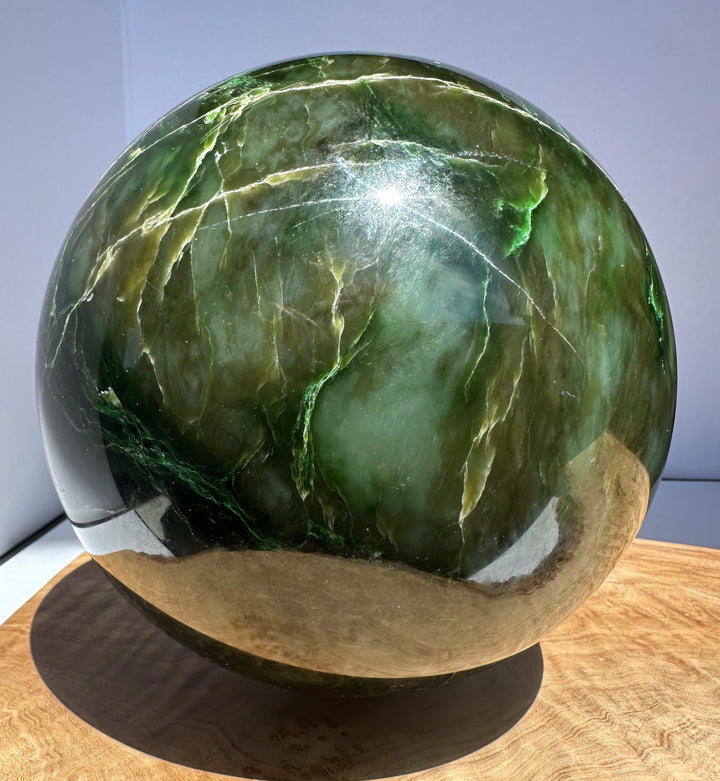 Top view of Polar Jade Sphere showing vivid greens and pale veins with a glossy finish