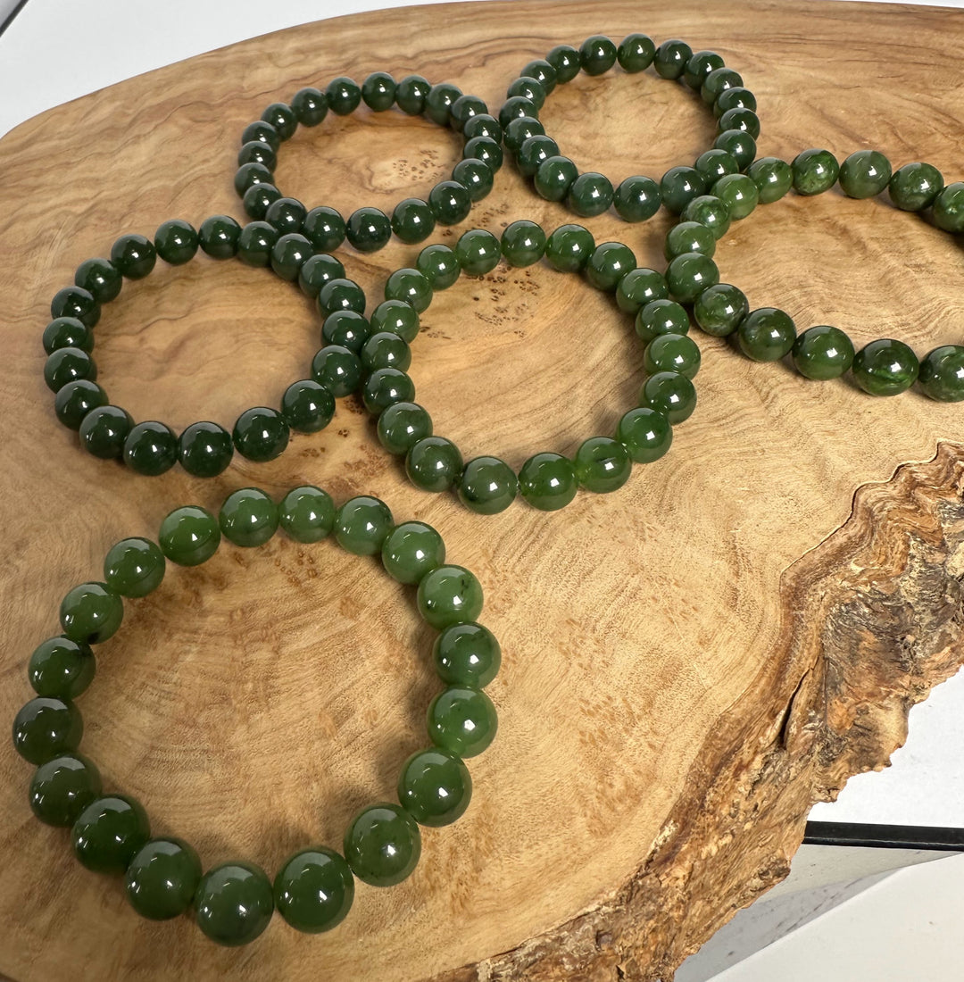 Green beaded bracelets on a wooden surface